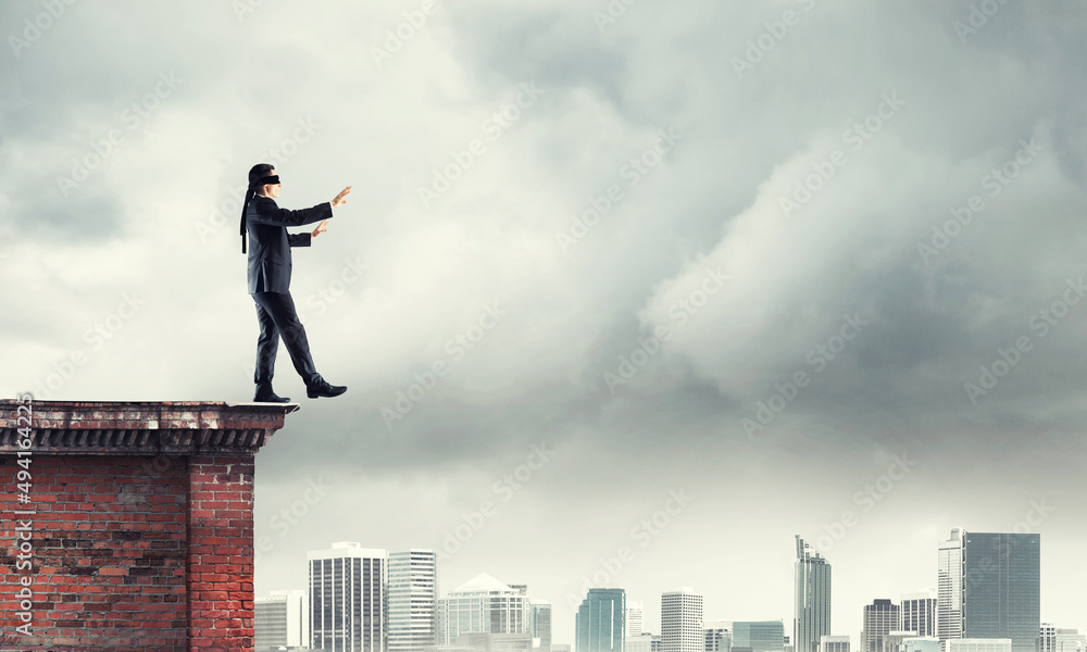 Danger and risk concept with businessman making step from edge Danger and risk concept with businessman making step from edge
