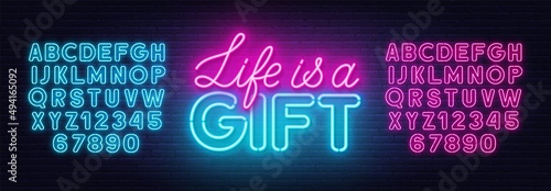 Life is a Gift neon lettering on brick wall background.