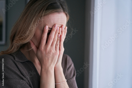 Depressed woman covering her face into hands