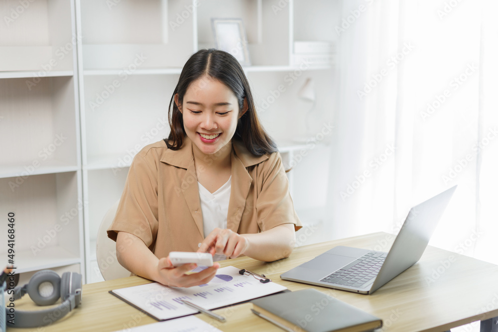 Online lifestyle concept A female worker calculating the total sale according to the charts on her paper. Online lifestyle concept A female worker calculating the total sale according to the charts on her paper.