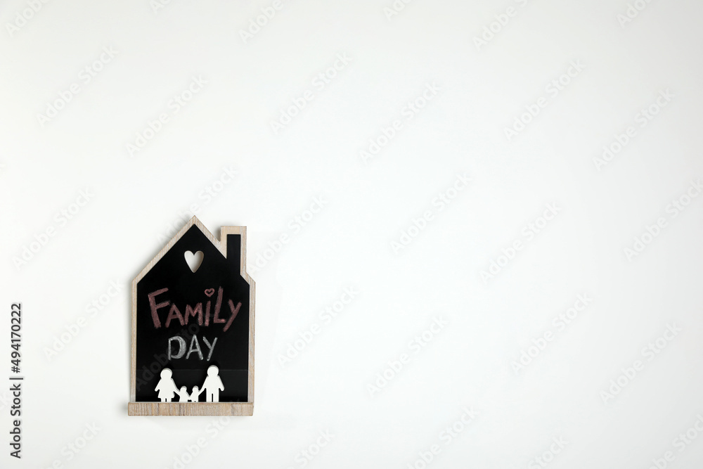 House shaped blackboard with phrase Family day and figures on white background. Space for text House shaped blackboard with phrase Family day and figures on white background. Space for text