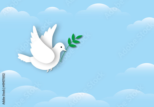 Paper white dove or pigeon carrying olive branch flying in cloudy sky background, Concept for World Peace Day, international day of peace, space for the text, paper cut design style.
