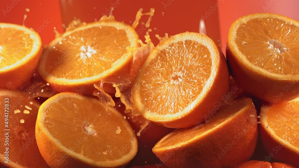 Slow Motion Shot of Orange Juice Splashing through Orange Slices Slow Motion Shot of Orange Juice Splashing through Orange Slices