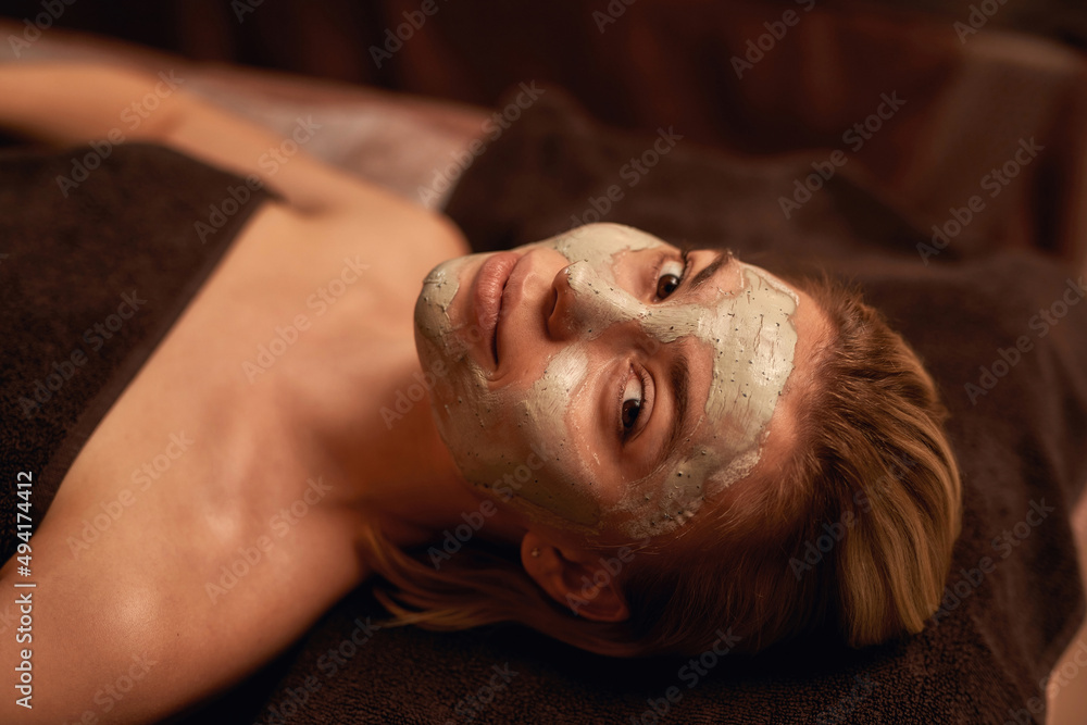 Top view of girl with clay mask looking at camera Top view of girl with clay mask looking at camera