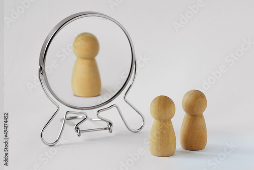 Couple of pawns looking in the mirror with just one of them reflected in it - Concept of egoism and narcissist photo