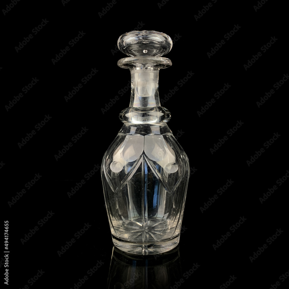 antique glass decanter with geometric pattern. retro decanter for alcohol on a black isolated background. engraved vintage decanter antique glass decanter with geometric pattern. retro decanter for alcohol on a black isolated background. engraved vintage decanter