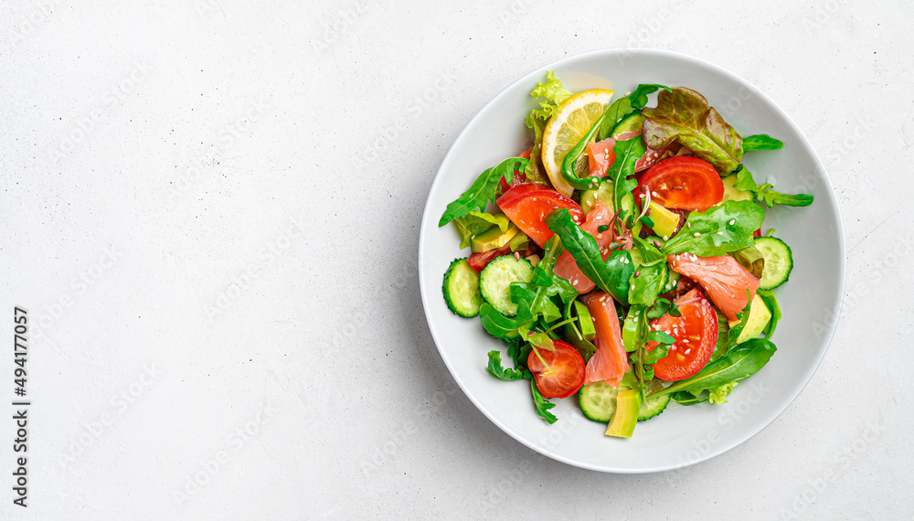 Salad with salmon, vegetables and fresh herbs on a light background. Salad with salmon, vegetables and fresh herbs on a light background.