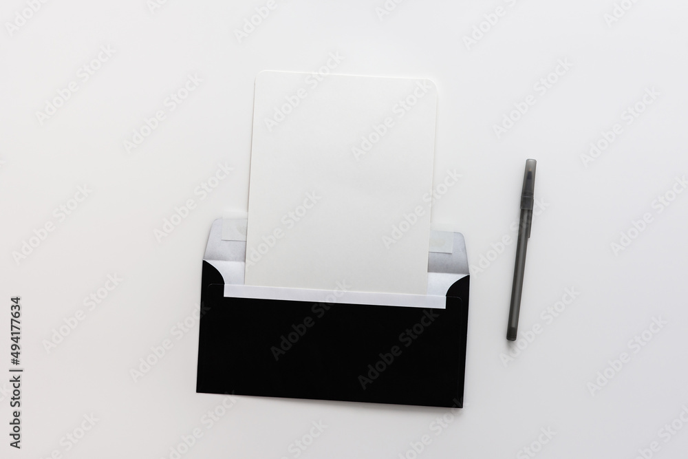 Black envelope with blank paper and pen, greeting card or invitation mockup, top view, copy space Black envelope with blank paper and pen, greeting card or invitation mockup, top view, copy space