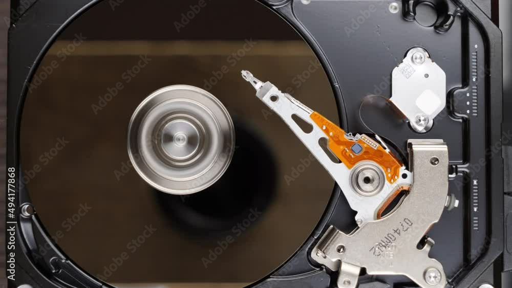 HDD spinning platter with moving read-write head. Hard disk drive starting. View from the top HDD spinning platter with moving read-write head. Hard disk drive starting. View from the top