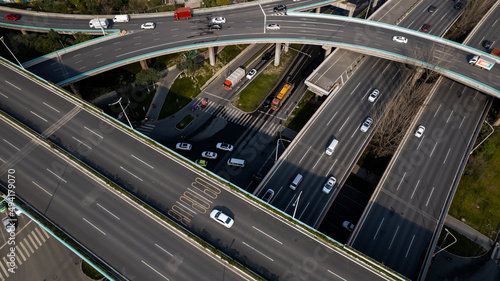 Top up aerial drone view of elevated road and traffic junctions in Chinese metropolis city Chengdu during sunny day. Modern construction design of traffic ways to avoid traffic jams. Few vehicles.