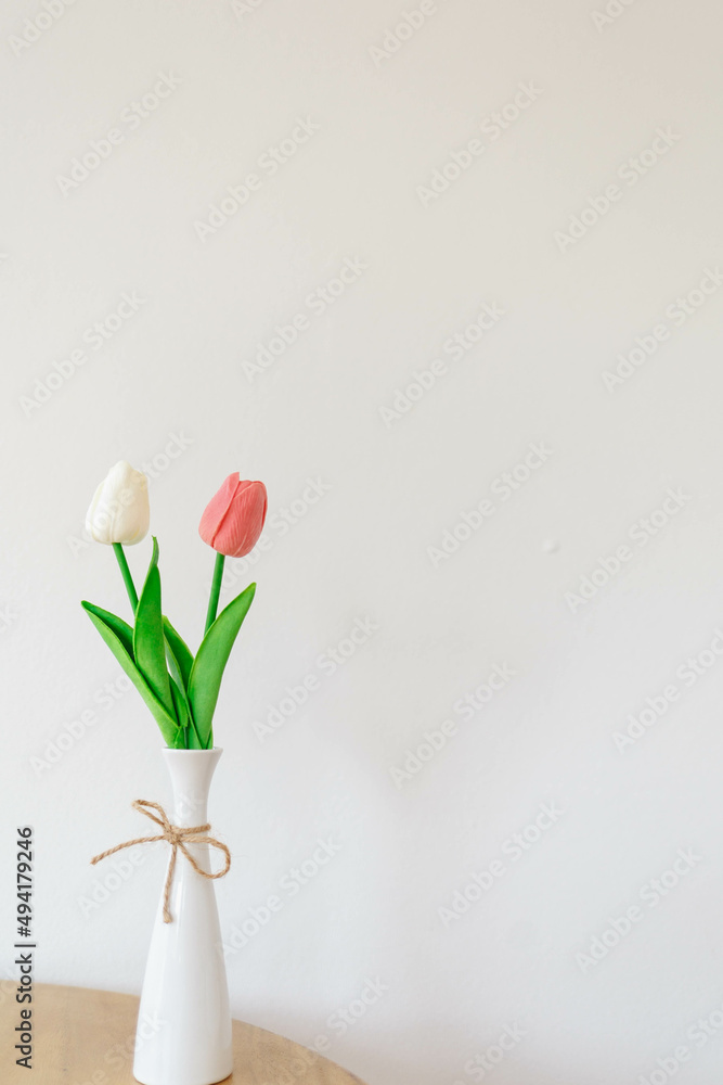 Tulips flower in a vase on a white background Tulips flower in a vase on a white background