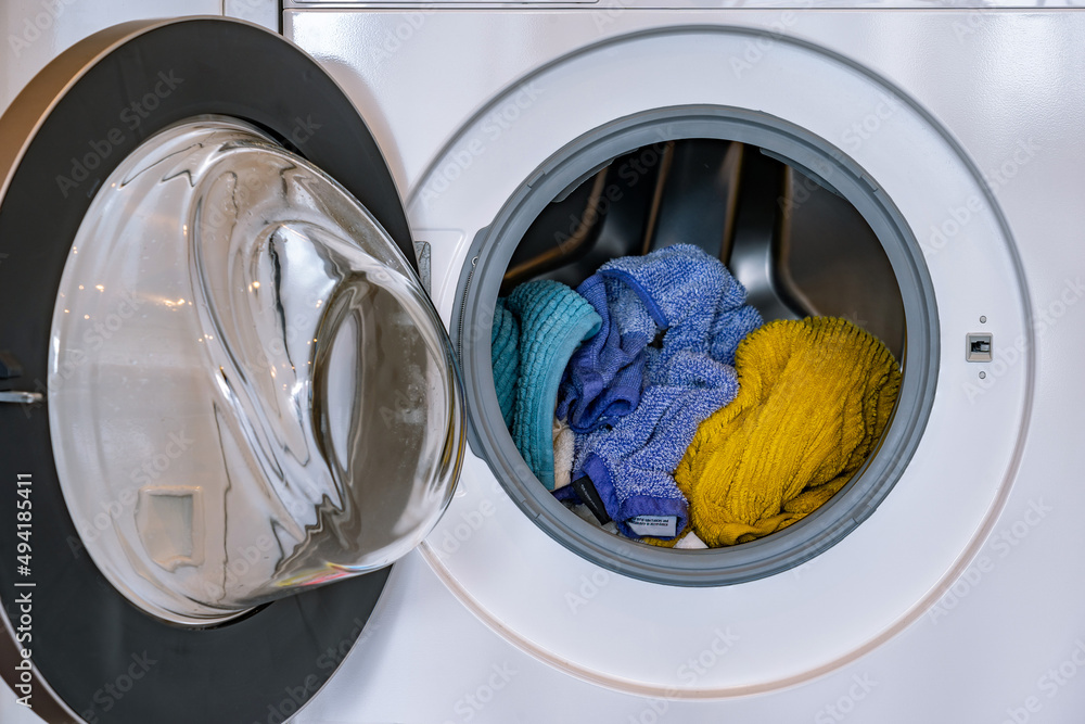 Colorful laundry inside a front loader washing machine Colorful laundry inside a front loader washing machine