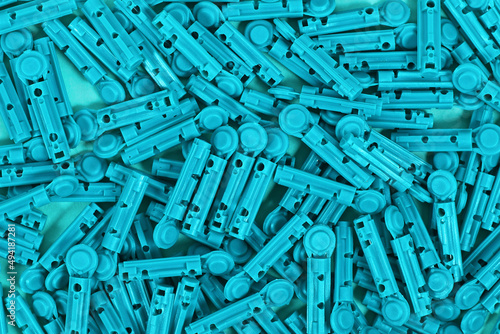 Many blue disposable diabetes lancets used to draw blood for testing