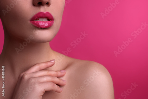 Closeup view of woman with beautiful full lips on pink background, space for text