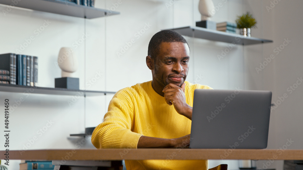 Young man typing on laptop keyboard at the desk at home Young man typing on laptop keyboard at the desk at home