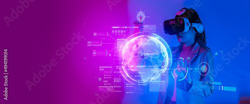 Young woman using glasses of virtual reality on dark background. Smartphone using with VR headset,virtual reality,future technology concept.Asian woman using VR glasses in colorful neon lights.