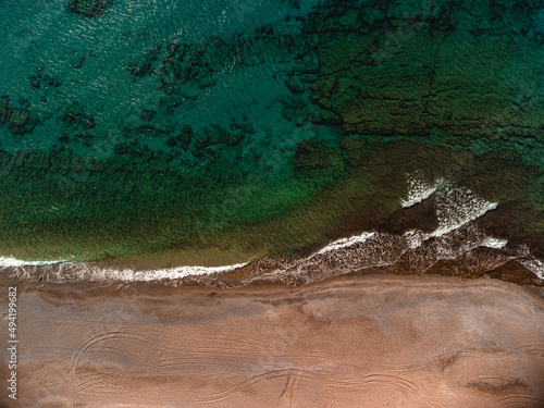 Top view of malachite emerald aquamarine water and sandy beach. Drone photo, sea green color