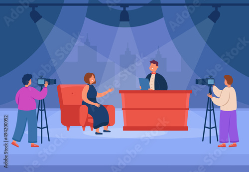 TV talk show with female celebrity flat vector illustration. Woman sitting on sofa and talking with host, discussing news in studio. Videographers filming broadcasting. Television, interview concept