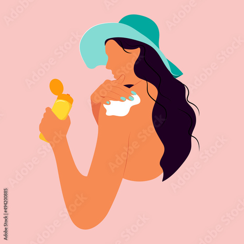 beautiful girl in a hat uses sunscreen