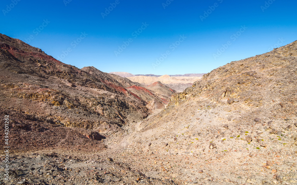 The trail goes through a rocky desert canyon.