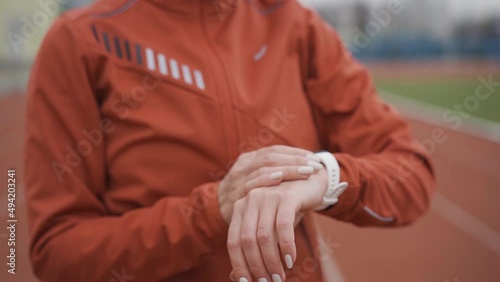 Woman in sportswear looking at fitness bracelet