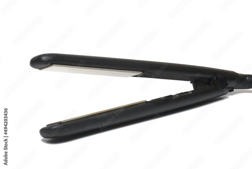 Closeup hair straightener black white background Closeup hair straightener black white background