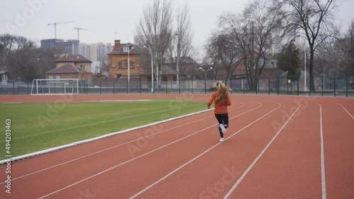 Portrait of woman in sportswear doing jogging at the stadium