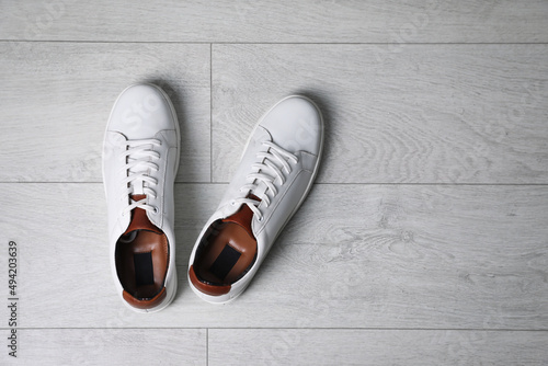 Pair of stylish sports shoes on white wooden floor, flat lay. Space for text