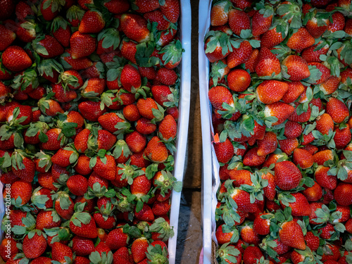 Fresh strawberries on the store counter. Colorful fruits are sold at the street market. Berries in plastic boxes