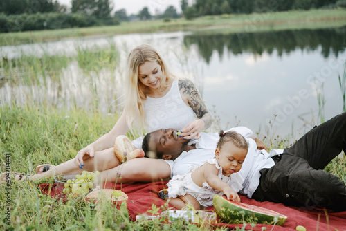 Multiracial couple and their daughter on vacation in nature