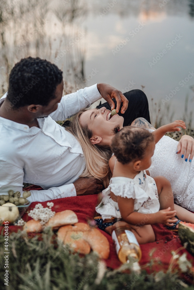 Little girl having picnic with her father and mother outdoors Little girl having picnic with her father and mother outdoors