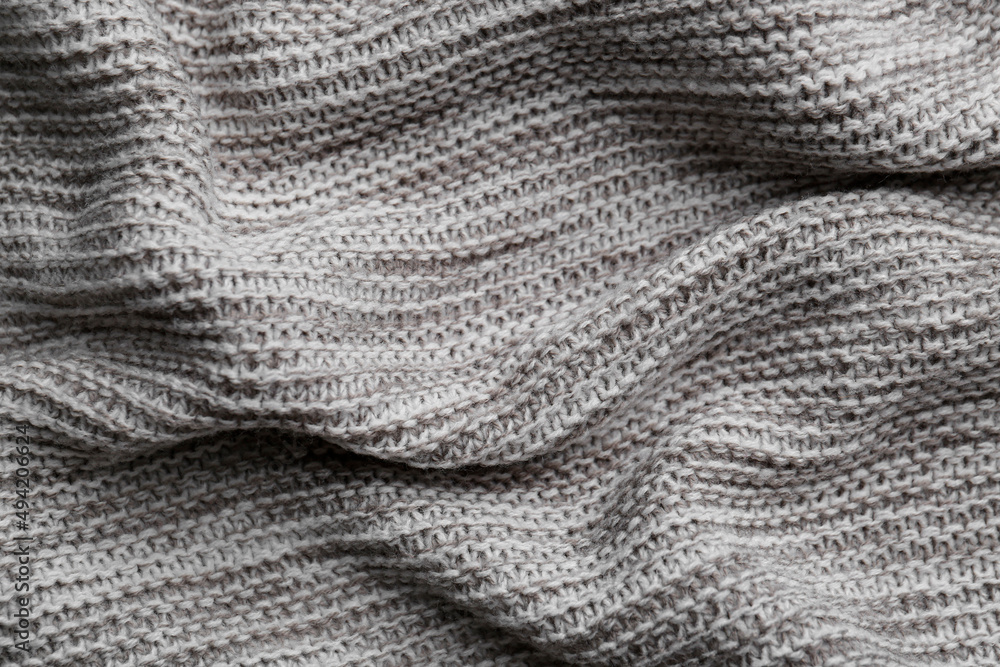Beautiful grey knitted fabric as background, top view Beautiful grey knitted fabric as background, top view