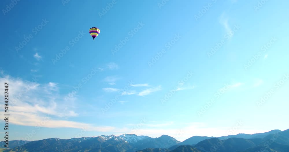Hot Air Ballon Flying Above Horizon Looking Down to Mountains at Sunrise - Wide Aerial View Hot Air Ballon Flying Above Horizon Looking Down to Mountains at Sunrise - Wide Aerial View