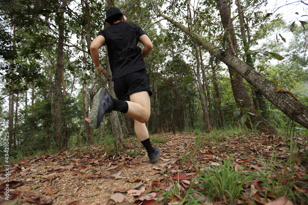 Woman runner running on forest trail Woman runner running on forest trail