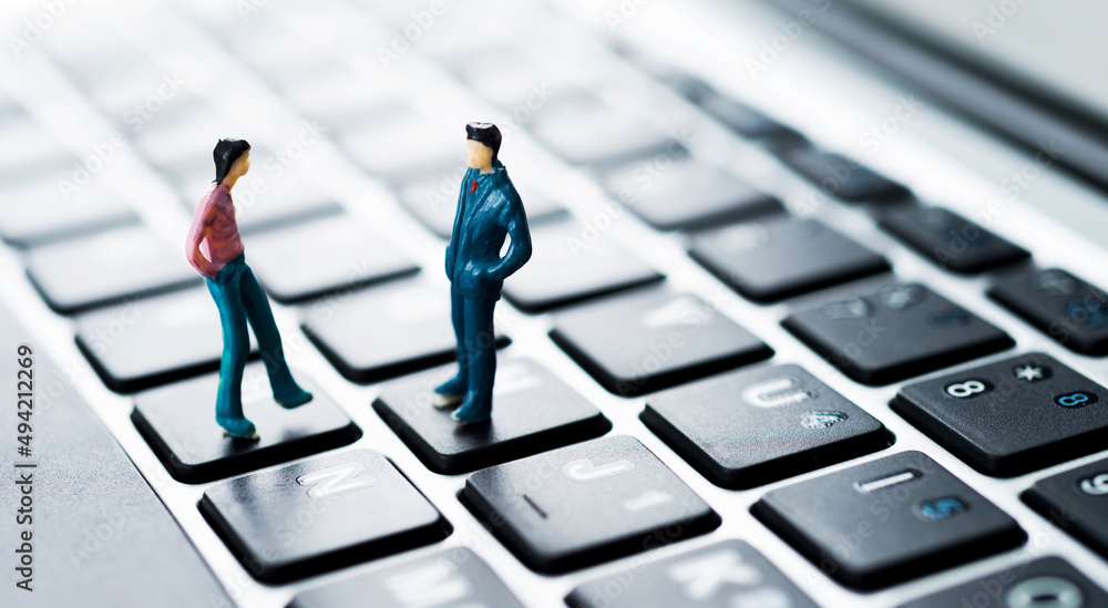 Miniature workers standing on top of keyboard Miniature workers standing on top of keyboard
