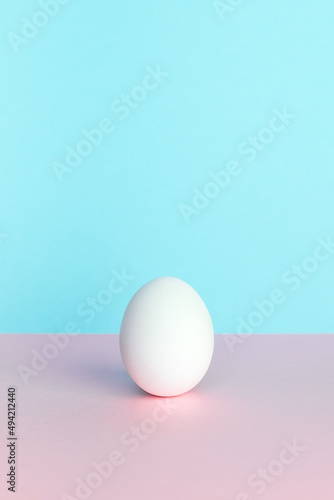 White Easter egg on pastel background. Happy Easter concept. Minimal concept.