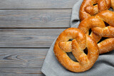 Tasty freshly baked pretzels on wooden table, flat lay. Space for text