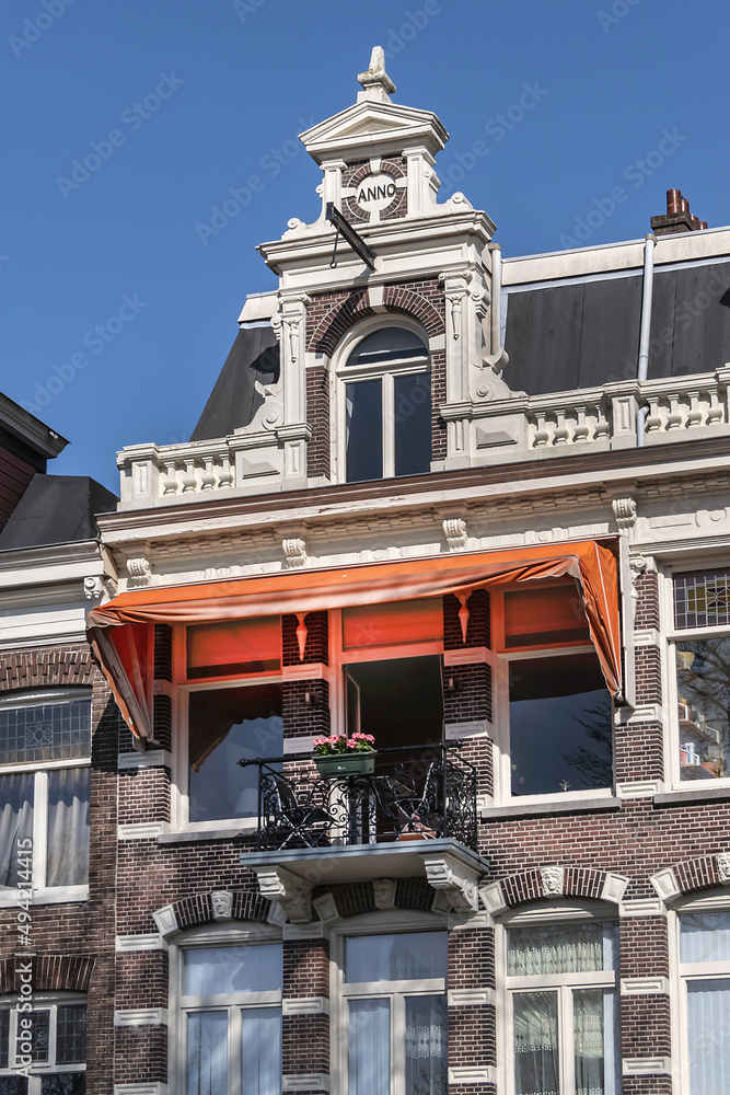Close-up view architectural details of old (1800s) colorful building along river Amstel. Amsterdam, the Netherlands.