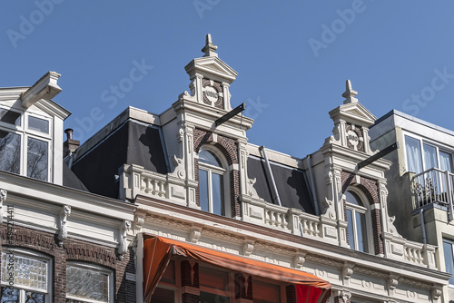 Close-up view architectural details of old (1800s) colorful building along river Amstel. Amsterdam, the Netherlands.