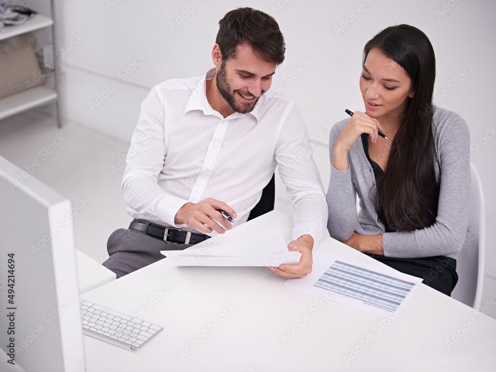 Fototapeta premium Giving her some good advice at work. Shot of two young business colleagues discussing documents in the office.