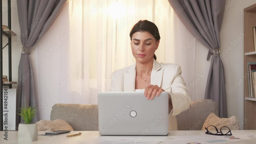 Finish work. Relieved woman. Successful project. Stylish elegant tired lady closing laptop breathing deep sitting desk in light office room interior.