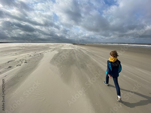 Kind läuft zügig über den Strand von Langeoog bei Ebbe