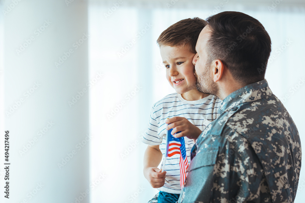 Happy soldier play with his son. Soldier enjoying at home with children. My Hero is back home. Little boy meeting his military father at home. Memorial Day celebration.. Happy soldier play with his son. Soldier enjoying at home with children. My Hero is back home. Little boy meeting his military father at home. Memorial Day celebration..