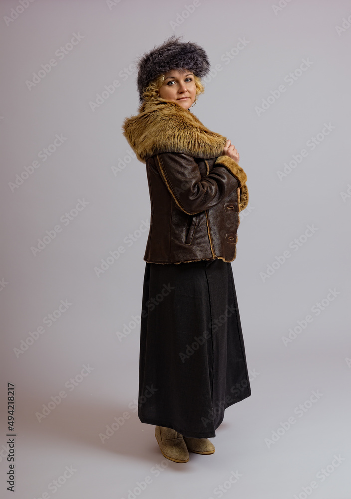 woman in warm fur clothes posing in full growth on a white background