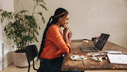 Tableau sur toile Smiling graphic designer attending an online meeting in her office
