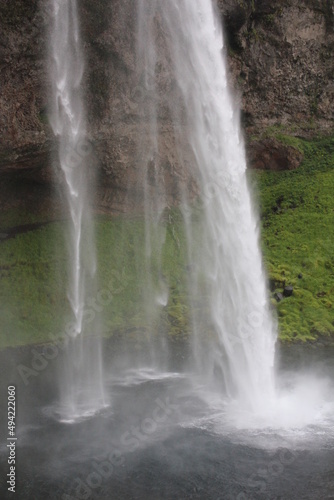 World famous Icelandic Seljalandsfoss waterfall with its characteristic veil (vertical), Seljalandsfoss, Iceland