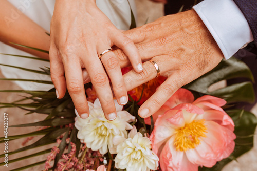 Close up portrait of wedding couple hands with rings and flower bouquet. 