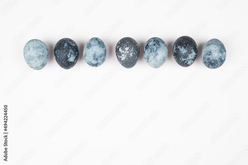 Close up of blue space galactic Easter eggs isolated on white. Easter greeting card with copy space.