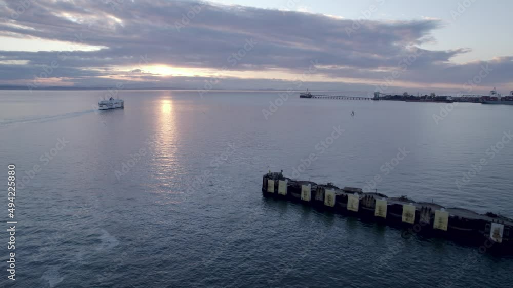 Aerial forward over Tsawwassen Vancouver terminal at sunset with ferry in background, British Columbia in Canada Aerial forward over Tsawwassen Vancouver terminal at sunset with ferry in background, British Columbia in Canada