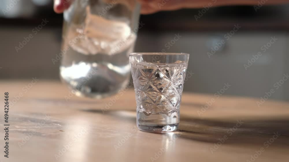 Unrecognizable man pouring vodka into a glass and drinking, close-up Unrecognizable man pouring vodka into a glass and drinking, close-up